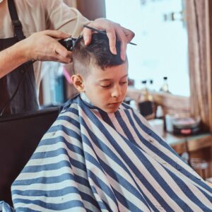 kids babes boy is getting trendy hairstyle from expirienced hairdresser modern barbershop haircut for children elegance elegantcy hair salon